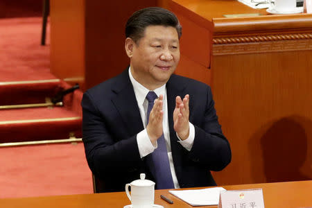 Chinese President Xi Jinping applauds after the parliament passed a constitutional amendment lifting presidential term limit, at the third plenary session of the National People's Congress (NPC) at the Great Hall of the People in Beijing, China March 11, 2018. REUTERS/Jason Lee