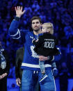 Toronto Maple Leafs center John Tavares holds his child during a pregame ceremony for reaching 1,000 career games, before an NHL hockey game against the Washington Capitals in Toronto on Sunday, Jan. 29, 2023. (Cole Burston/The Canadian Press via AP)