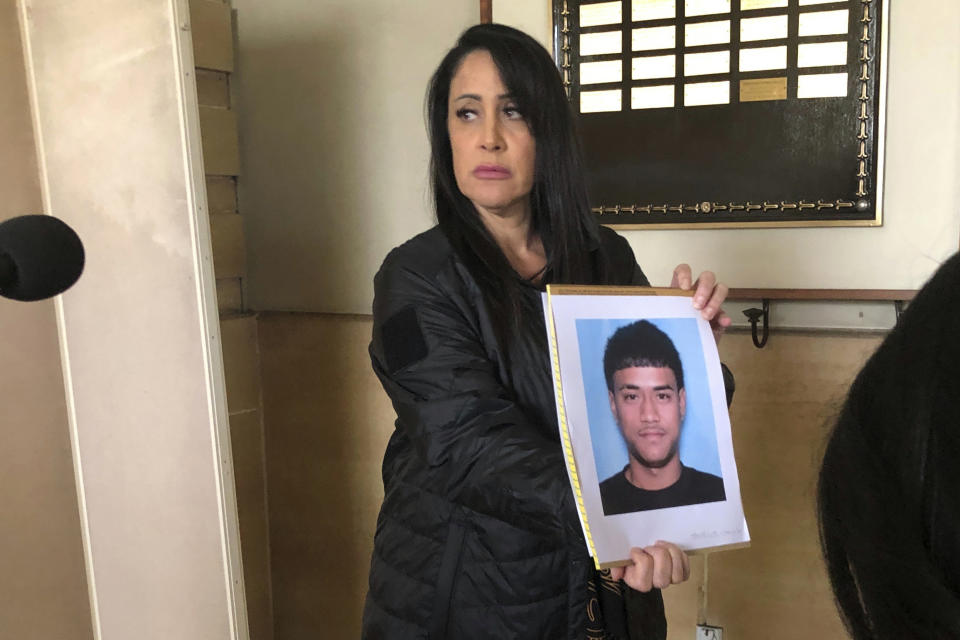 Lt. Deena Thoemmes, the lead homicide investigator for the Honolulu Police Department's Criminal Investigation Division, holds a photo of Jacob Borge, one of two suspects in a shooting Saturday, April 15, that killed two people and injured three others after a cockfight, during a news conference in Honolulu, Tuesday, April 18, 2023. Police in Hawaii have vowed to step up illegal gambling enforcement after one of the most serious shootings in state history called attention to the dangers that come with cockfighting, which has deep roots in the islands and remains popular despite being illegal. (AP Photo/Audrey McAvoy)