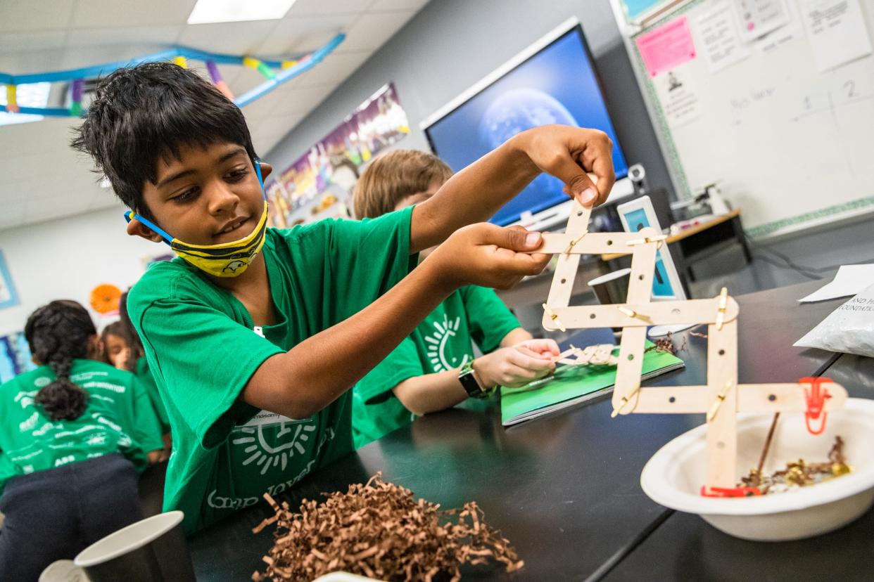 Pavnas Ramasamy uses a grabbing device to pick up objects during a game at Camp Invention at Windsor Park Elementary School on Thursday, June 16, 2022.