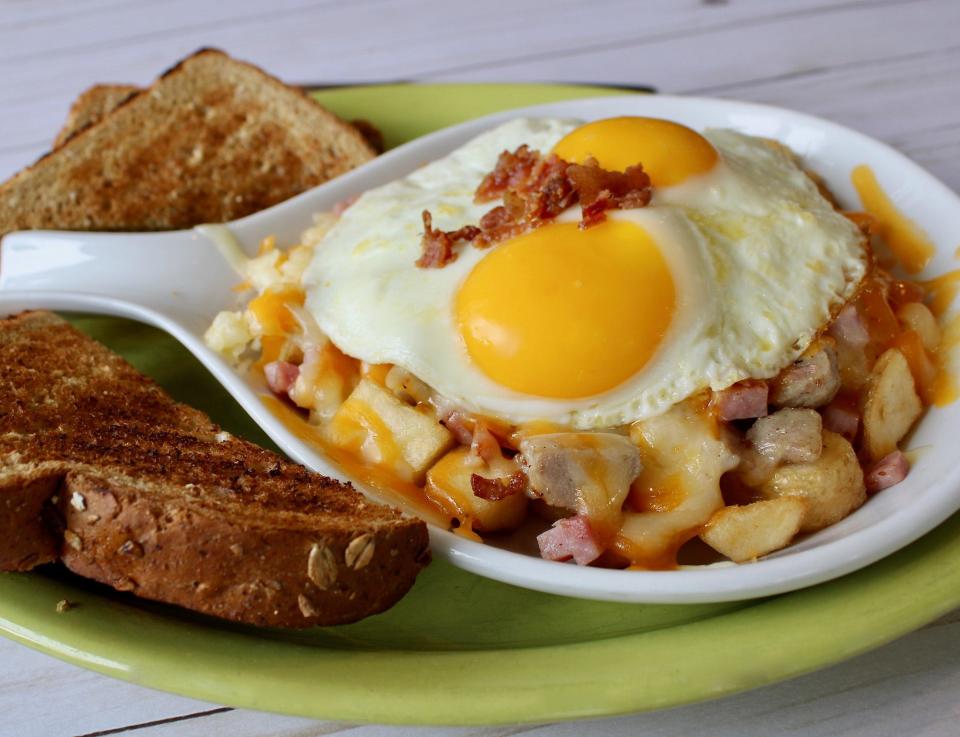 A Scramblers customer favorite: Uncle Moose's Manhandler Skillet with bacon, ham, sausage, onions and a blend of monterey jack and cheddar cheeses on a bed of skin-on potato chunks then topped with two eggs any style.