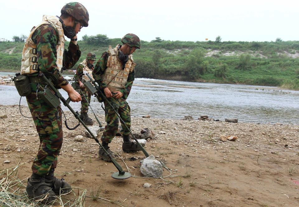 FILE - In this Aug. 1, 2010 file photo, South Korean Army soldiers search for landmines near the demilitarized zone that separates the two Koreas in Yeoncheon, north of Seoul, South Korea. North and South Korea began removing mines at two sites inside their heavily fortified border Monday, Oct. 1, 2018, as part of their recent deals to ease decades-long military tensions.(Lim Byung-shick/Yonhap via AP, File)