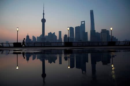 A security guard walks on the bund in front of the financial district of Pudong in Shanghai, China July 27, 2017. REUTERS/Aly Song