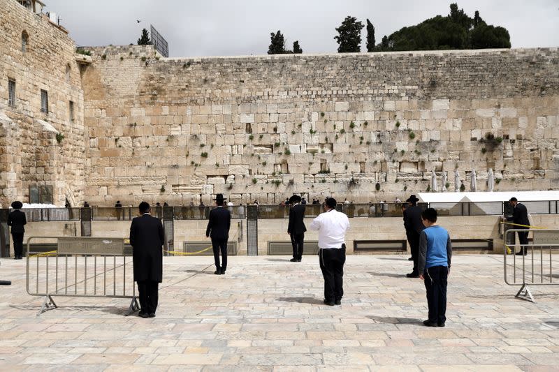 Jewish worshippers stand apart as they practice social distancing in keeping with government restrictions aimed at halting the spread of the coronavirus disease (COVID-19) as they pray at the plaza of the Western Wall in Jerusalem's Old City