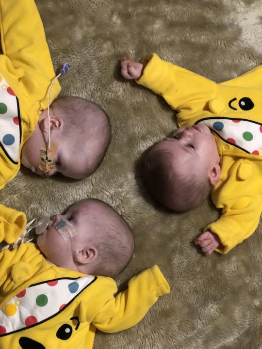 Triplets Rubi-Rose, Payton Jane and Porscha-Mae dressed in Pudsey bear onesies (Guinness World Records)