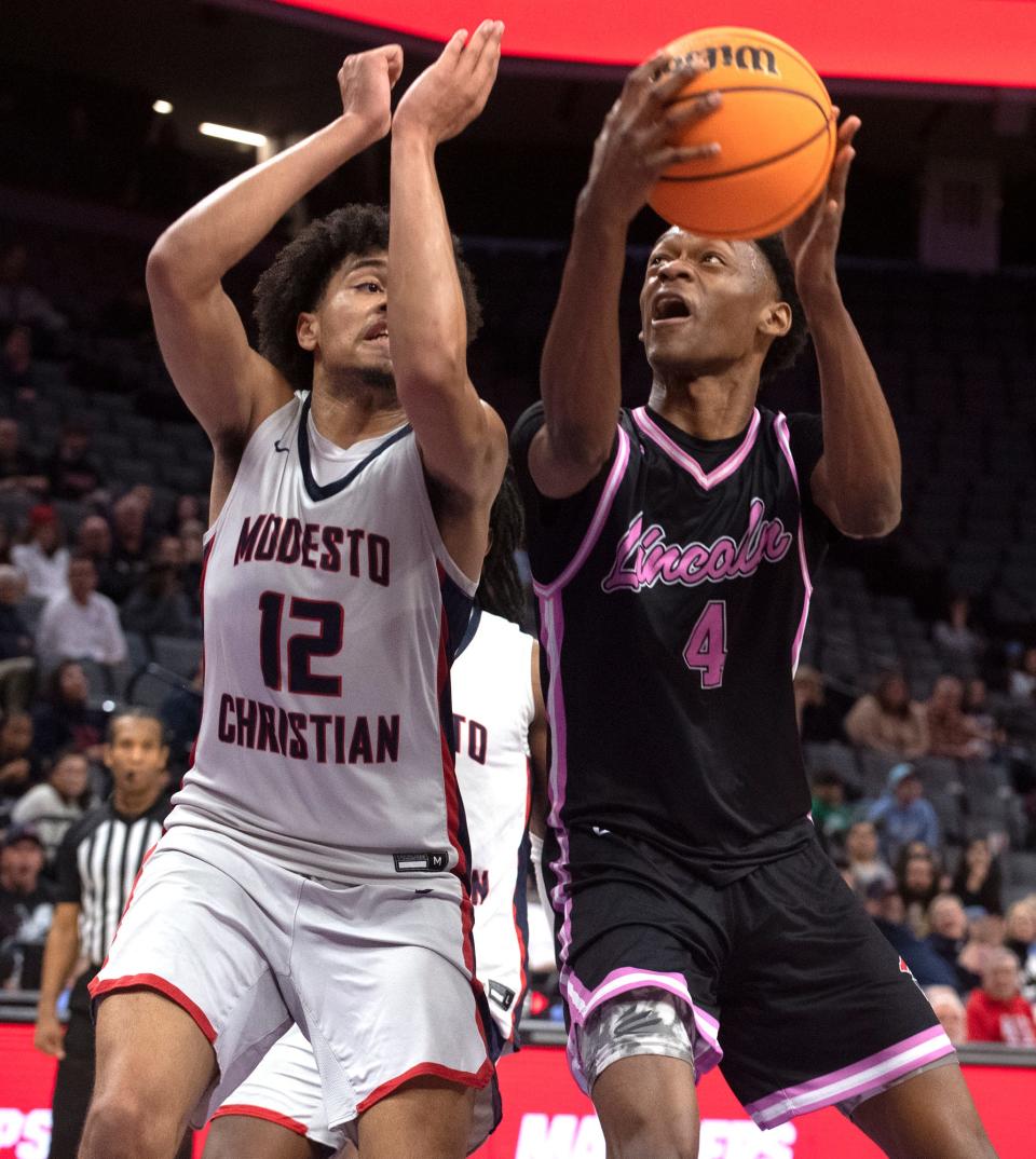 Lincoln's Anthony Moore, right, goes to the hoop against Modesto Christian's Marcus Washington during the Sac-Joaquin Section boys basketball championship game at Golden One Center in Sacramento on Feb. 21. 2024. Modesto Christian won 68-63.