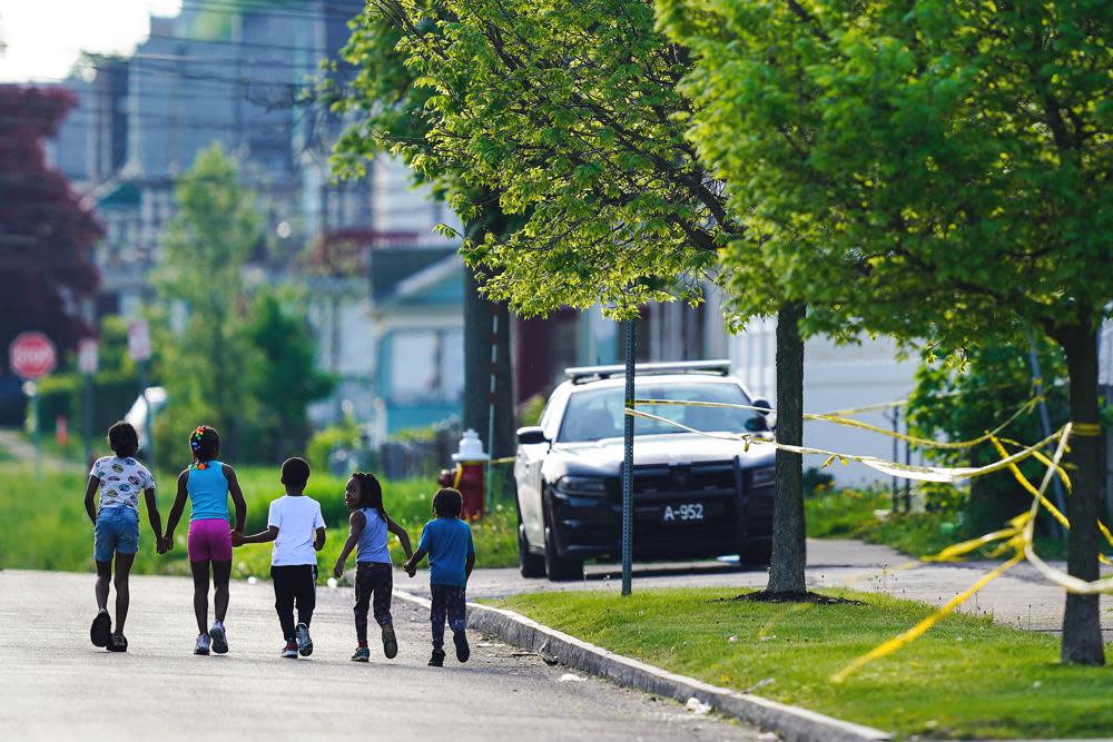 Children walk hand-in-hand near the scene of a shooting at a supermarket in Buffalo, N.Y., May 15, 2022. (AP Photo/Matt Rourke, File)