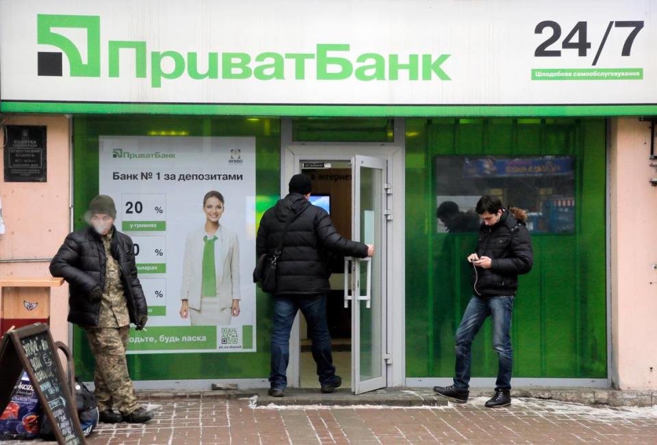 Un cliente entra en PrivatBank mientras otros clientes esperan en el centro de Kiev, Ucrania, el lunes 19 de diciembre de 2016. Ucrania nacionalizó su mayor banco, el PrivatBank, debido a la preocupación por su estabilidad. (AP Photo/Efrem Lukatsky)