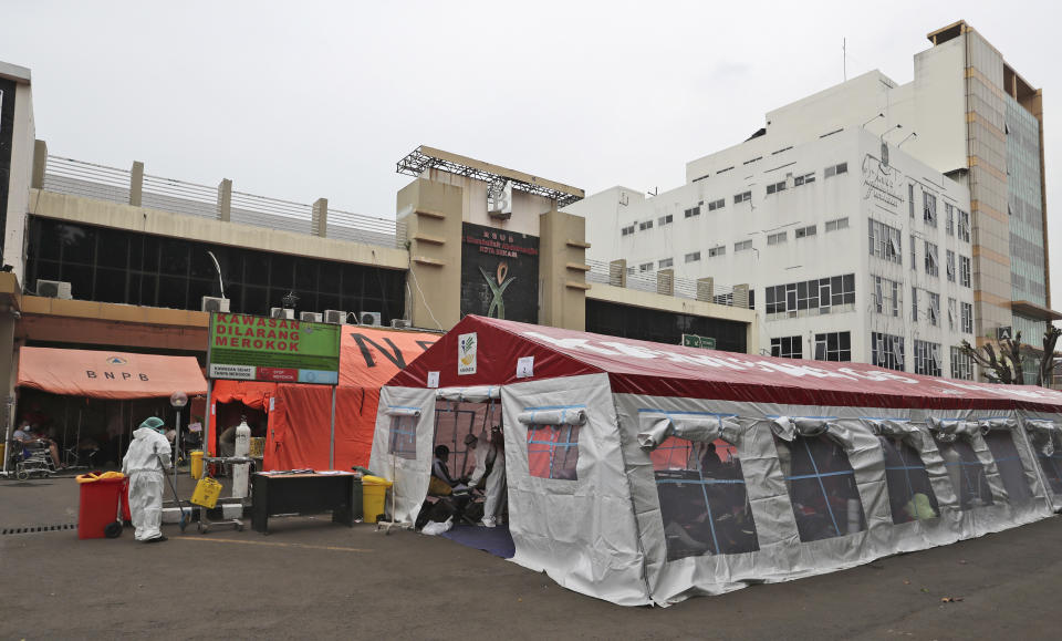 Emergency tents erected to accommodate a surge of COVID-19 patients are seen at the parking lot of a government hospital in Bekasi, on the outskirts of Jakarta, Indonesia, Monday, June 28, 2021. After a slow vaccination rollout, Indonesia is now racing to inoculate as many people as possible as it battles an explosion of cases that have overburdened its health care system. (AP Photo/Achmad Ibrahim)