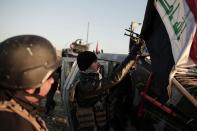 Iraqi federal police forces attach an Iraqi flag to a humvee before going to battle against the Islamic State, in Hamam al-Alil, Iraq, Sunday, Feb. 2017. U.S.-backed Iraqi forces launched a large-scale military operation to dislodge Islamic State militants from the western half of Mosul city on Sunday. (AP Photo/Bram Janssen)