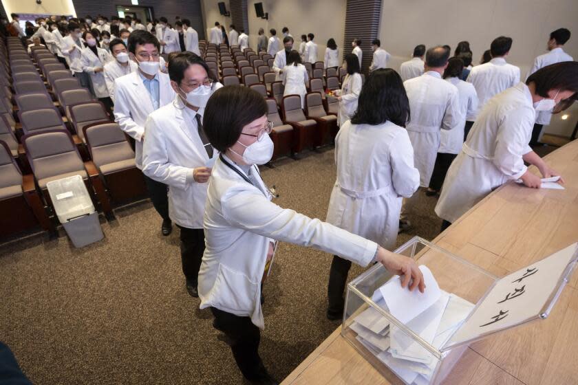 Medical professors queue to submit their resignations during a meeting at Korea University in Seoul, South Korea, Monday, March 25, 2024. Senior doctors at dozens of hospitals in South Korea planned to submit their resignations Monday in support of medical interns and residents who have been on a strike for five weeks over the government's push to sharply increase medical school admissions, their leader said.(Yoon Dong-jin/Yonhap via AP)