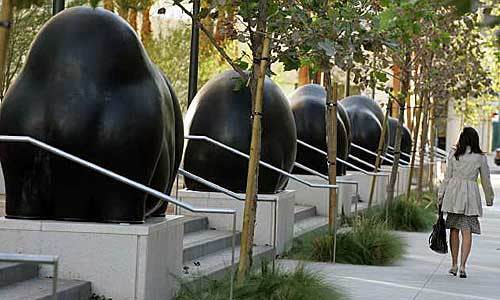 A woman walks past an art installation on Spring Street