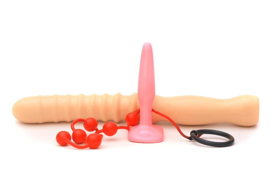 Close-up of sex toys: a dildo, anal beads, and a butt plug