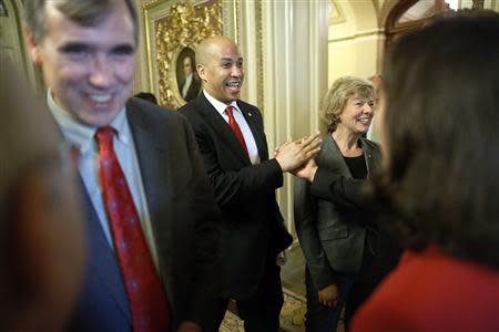 U.S. Senator Jeff Merkley (D-OR) (L-R), Senator Cory Booker (D-NJ) and Senator Tammy Baldwin (D-WI) celebrate with supporters after a vote to pass the Employment Non-Discrimination Act (ENDA), legislation to ban workplace discrimination against gays, at the U.S. Capitol in Washington November 7, 2013. REUTERS/Jonathan Ernst