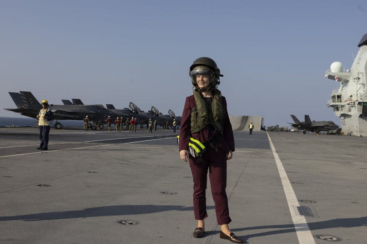 Liz Truss standing on the deck of an aircraft carrier.