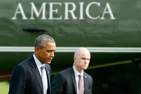 U.S. President Barack Obama (R) arrives via Marine One helicopter at the White House in Washington October 14, 2014. REUTERS/Jonathan Ernst