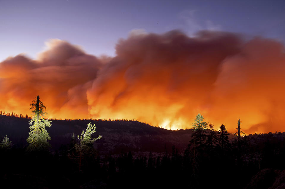 FILE - In this Sunday, Aug. 29, 2021 file photo, the Caldor Fire burns in Eldorado National Forest, Calif. Last week, managers overseeing the fight against the massive wildfire scorching California's Lake Tahoe region thought they could have it contained by the start of this week. Instead, on Monday, Aug. 30, 2021, the Caldor Fire crested the Sierra Nevada, forcing the unprecedented evacuation of all 22,000 residents of South Lake Tahoe. (AP Photo/Noah Berger)