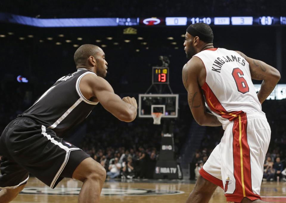 Brooklyn Nets' Alan Anderson, left, defends against Miami Heat's LeBron James, right, during the first half of an NBA basketball game on Friday, Jan. 10, 2014, in New York. Both teams wore nicknames on their jerseys during the game. (AP Photo/Frank Franklin II)