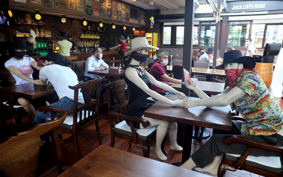 Mannequins are seen placed at tables to make customers sit according to social distancing rules at Elpaso Bar in Turkey - Adem Altan/AFP