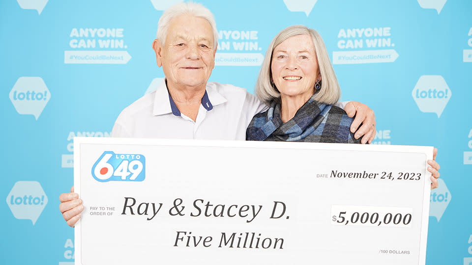Couple holding a $5 million cheque. 