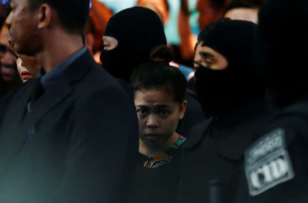 Indonesian Siti Aisyah, who is on trial for the killing of Kim Jong Nam, the estranged half-brother of North Korea's leader, is escorted as she revisits the Kuala Lumpur International Airport 2 in Sepang, Malaysia October 24, 2017. REUTERS/Lai Seng Sin/Files