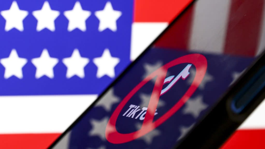  In this photo illustration, logo of Tiktok is displayed on mobile phone screen in front of flag of United States. 