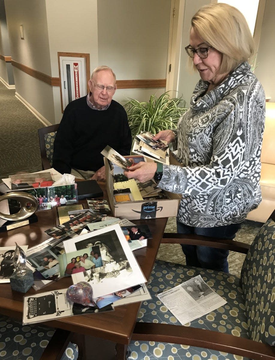 Art Oakford and his daughter Betsy Hamilton look through a box of photos and mementos from years of philanthropic work in central Illinois.