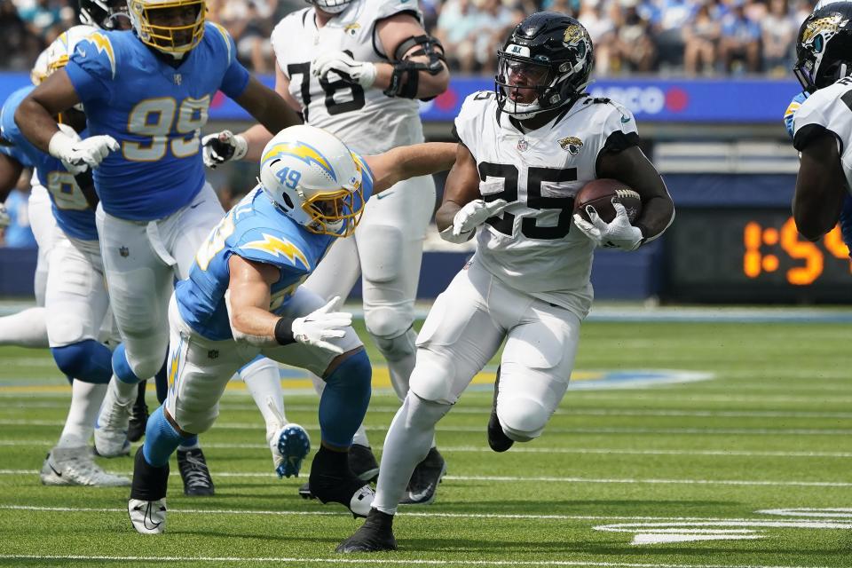 Jacksonville Jaguars running back James Robinson (25) runs against Los Angeles Chargers linebacker Drue Tranquill during the first half of an NFL football game in Inglewood, Calif., Sunday, Sept. 25, 2022. (AP Photo/Marcio Jose Sanchez)