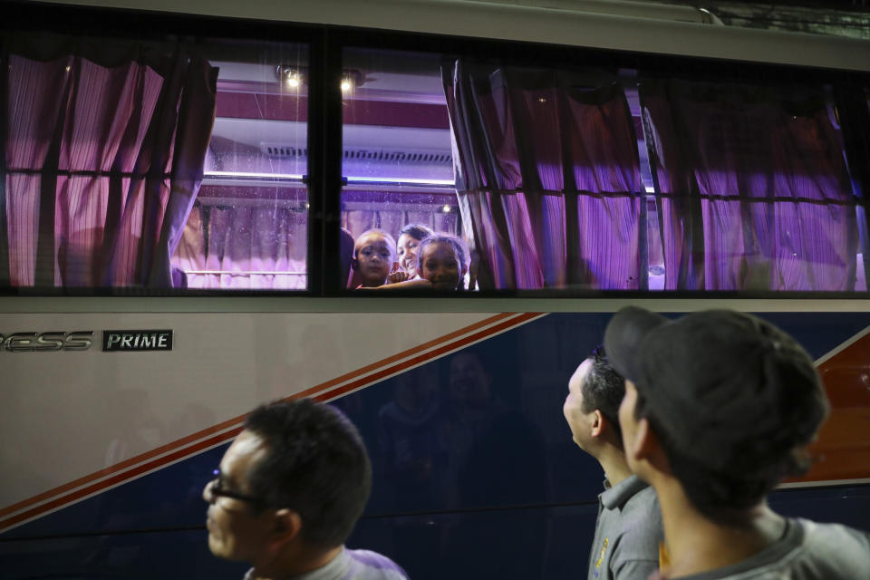 Migrant children look out from the window of a bus that will take them to the Guatemalan border, as families say goodbye in Tegucigalpa, Honduras, Tuesday, Aug. 20, 2019. In the past year, President Donald Trump has repeatedly bashed the Honduran government for not doing more to keep its people from migrating. (AP Photo/Eduardo Verdugo)