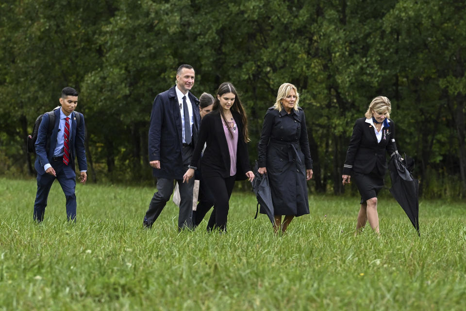 La primera dama Jill Biden camina por el campo tras visitar un monumento conmemorativo en el sitio donde cayó el Vuelo 93 de United Airlines durante los atentados del 11 de septiembre de 2001, acompañada por familiares de las personas que murieron a bordo, el domingo 11 de septiembre de 2022, en Shanksville, Pensilvania. (AP Foto/Barry Reeger)