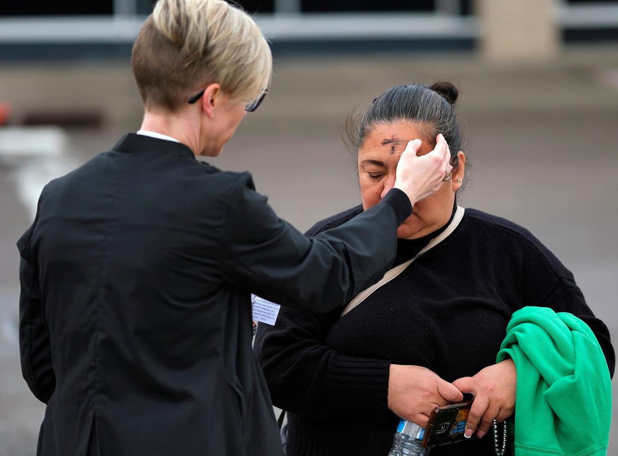 The Most Rev. Katie Churchwell, dean of St. Paul's Episcopal Cathedral, administers the imposition of ashes to Patricia Carino on her way to work. St. Paul's Episcopal Cathedral conducted Ashes to Go, for an Ash Wednesday outreach at NW 7 and Broadway in downtown Oklahoma City.