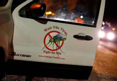 A vector control team vehicle displays a sign warning of West Nile Virus before the early morning spraying of a neighborhood due to increasing numbers of mosquitoes having tested positive for West Nile virus in San Diego, California, U.S. May 18, 2016. REUTERS/Mike Blake