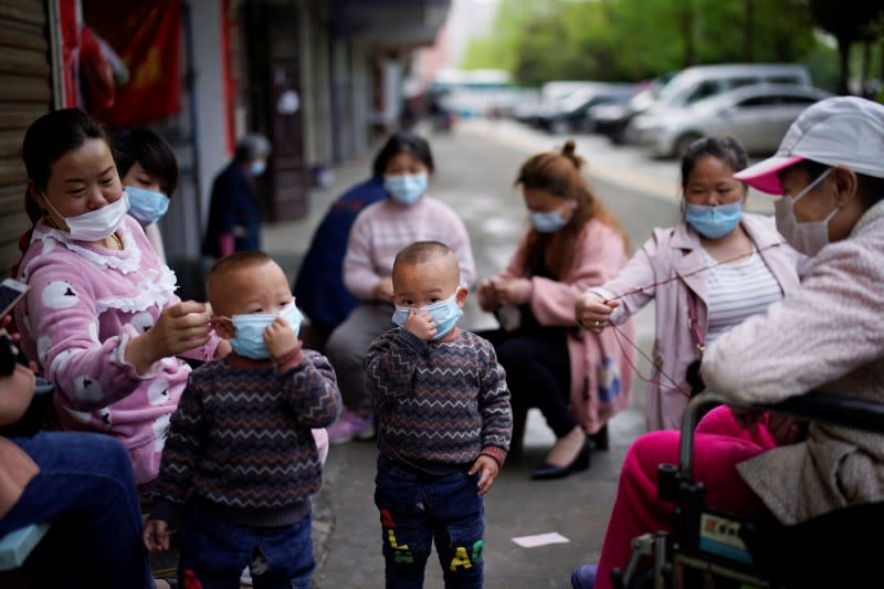 Niños y mujeres con máscaras faciales en Xianning