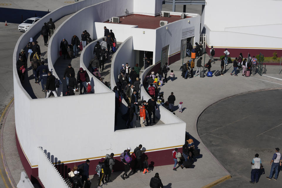 Migrants seeking asylum enter the U.S. Wednesday, Dec. 21, 2022, in Tijuana, Mexico. Thousands of migrants gathered along the Mexican side of the southern border Wednesday, camping outside or packing into shelters as they waited for the U.S. Supreme Court to decide whether and when to lift pandemic-era restrictions that have prevented many from seeking asylum. (AP Photo/Marcio Jose Sanchez)