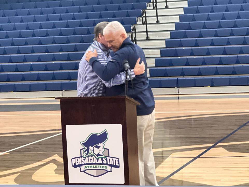 Pete Pena and Joe Ambersley exchange hugs during the unveiling ceremony Oct. 12 at Pensacola State College's Hartsell Arena to name court in their honor.