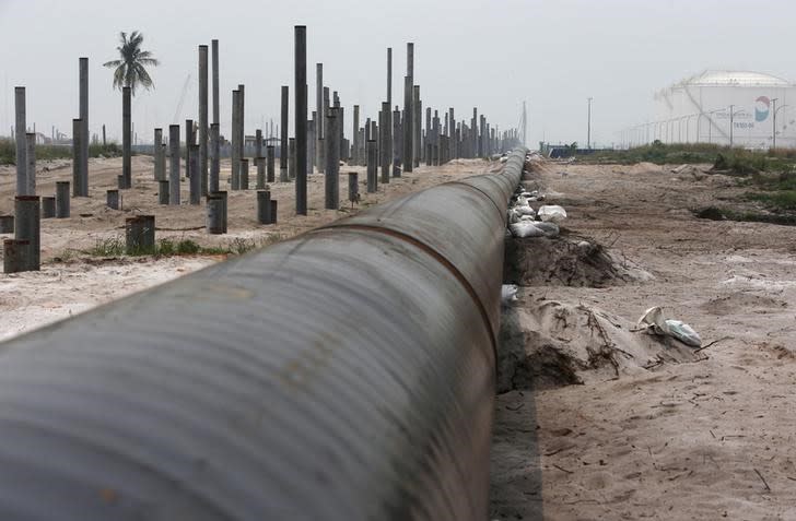 An oil pipeline is laid next to the Vopak-Dialog oil storage facility (R) and a Refinery and Petrochemical Integrated Development (RAPID) project construction site in Pangerang in Malaysia's southern state of Johor October 6, 2015. REUTERS/Edgar Su