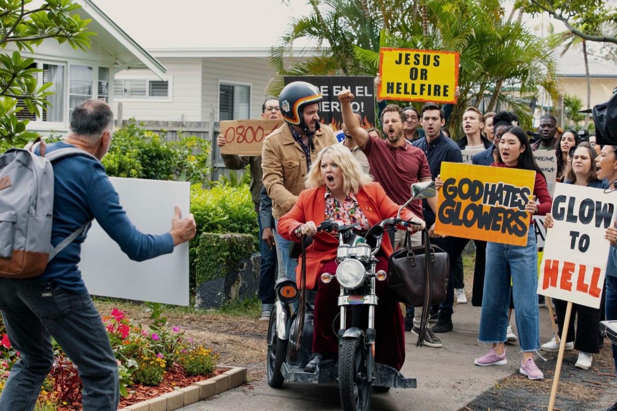 Der Erleuchtete braucht Hilfe: Amily (Melissa McCarthy) rettet ihren Kollegen Clark (Ben Falcone) vor einem wütenden Mob. (Bild: © Netflix/Vince Valitutti)