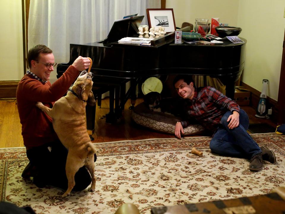 chasten and pete buttigieg playing with their dog at home