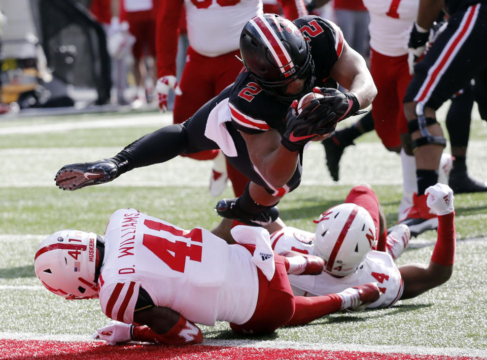 Ohio State running back J.K. Dobbins, top, dives into the end zone over Nebraska defenders Deontai Williams, left, and Tre Neal during the first half of an NCAA college football game Saturday, Nov. 3, 2018, in Columbus, Ohio. (AP Photo/Jay LaPrete)