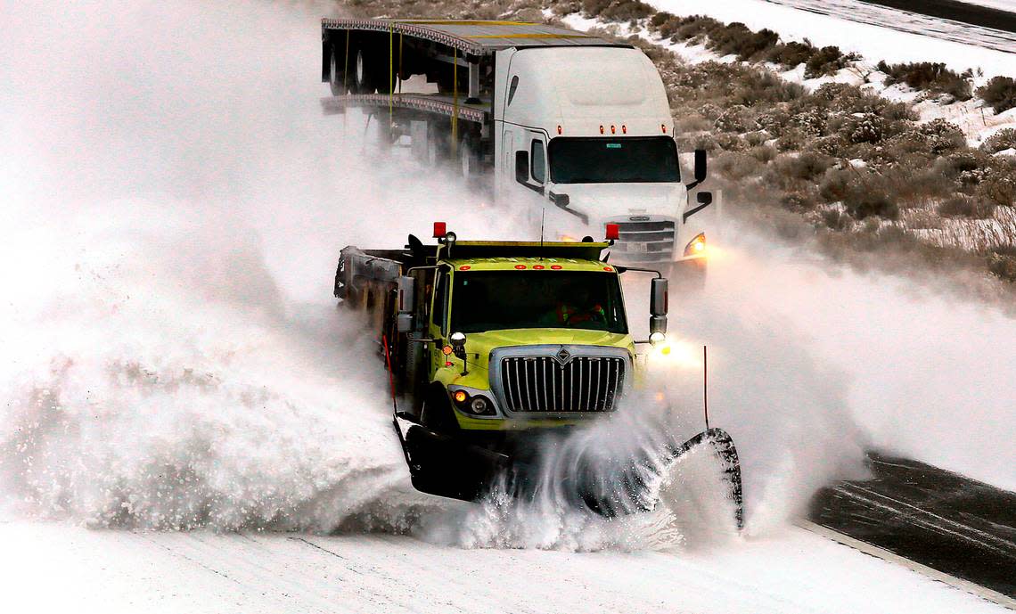 A WSDOT snow plow kicks up a heavy cloud of snow from the shoulder of Interstate 82 south of Kennewick early Friday after an overnight snowstorm coated the region with more of the frozen precipitation.