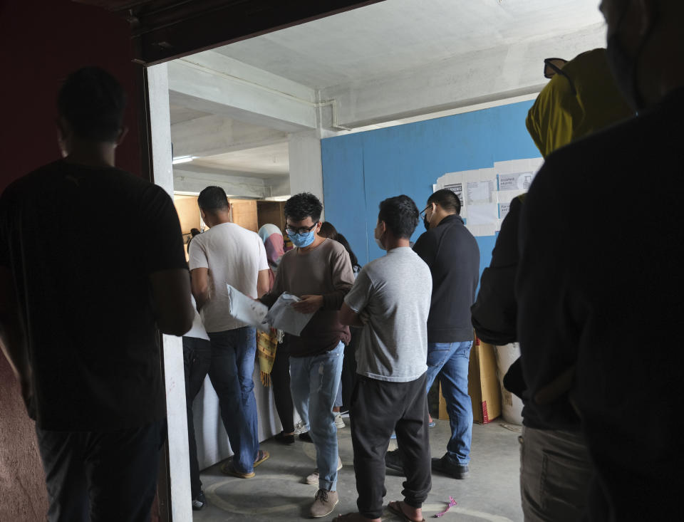 A man looks at packages after picking them up, as others wait in a queue to receive theirs at an Amazon office in Kohima, capital of the northeastern Indian state of Nagaland, Friday, May 29, 2020. India’s economic growth will fall to 4.2% in financial year 2019-20 as compared to 6.1% in the previous year and likely to contract this year because of the coronavirus pandemic. Millions of workers have fled cities after losing their jobs as authorities imposed the lockdown in March and started easing it early this month to promote economic activity. (AP Photo/Yirmiyan Arthur)