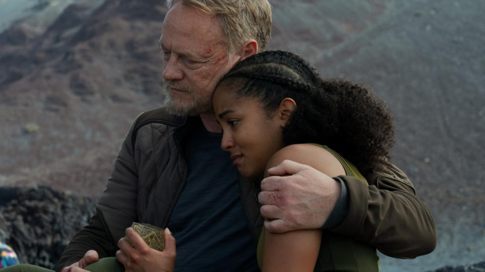 Jared Harris comforts an upset Lou Llobell near a rock formation in Foundation Season 2.