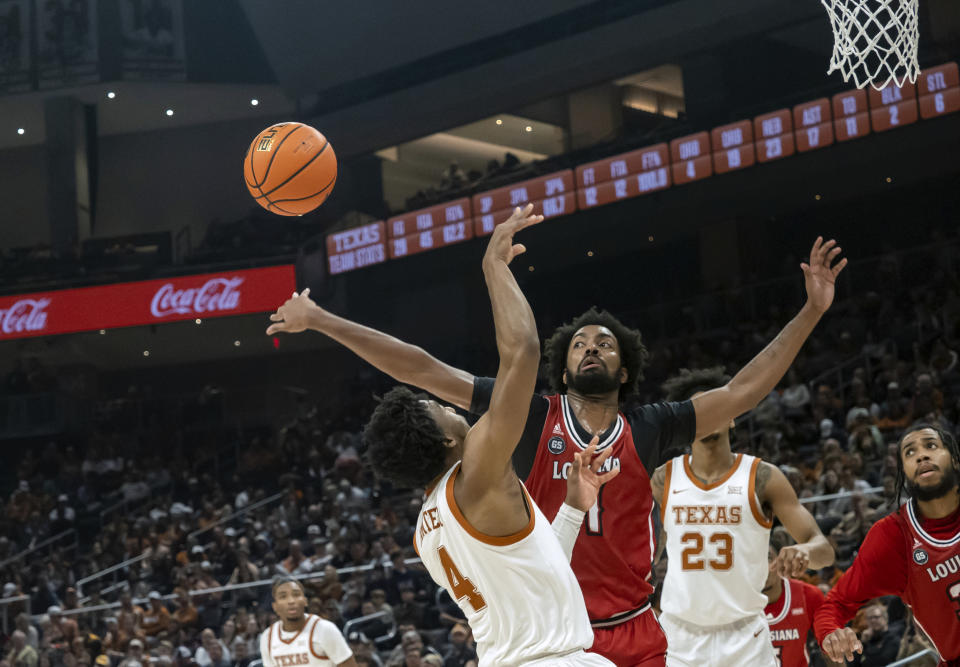 Louisiana-Lafayette forward Jordan Brown, right, blocks the shot of Texas guard Tyrese Hunter, left, during the second half of an NCAA college basketball game, Wednesday, Dec. 21, 2022, in Austin, Texas. Texas won 100-72.(AP Photo/Michael Thomas)