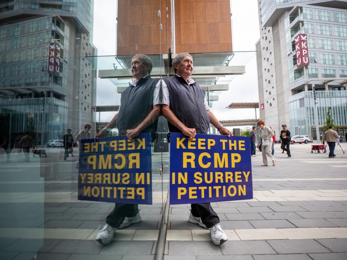 Ivan Scott of the Keep the RCMP in Surrey group outside City Hall in July 2019, gathering signatures for a petition to save the RCMP in the city. Members of the organization filed a petition in December 2021 challenging the city's amendments to the political signs bylaw. (Ben Nelms/CBC - image credit)