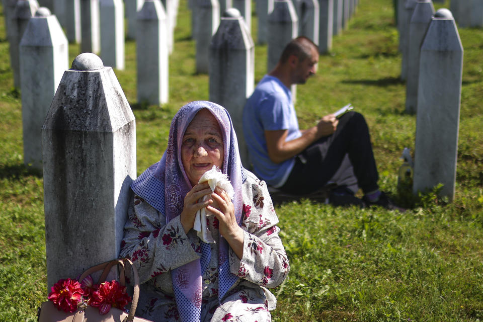 A Bosnian muslim woman mourns next to the grave of her relative, victim of the Srebrenica genocide, at the Srebrenica Memorial Centre, in Potocari, Bosnia, Thursday, July 11, 2024. Thousands gather in the eastern Bosnian town of Srebrenica to commemorate the 29th anniversary on Monday of Europe's only acknowledged genocide since World War II. (AP Photo/Armin Durgut)