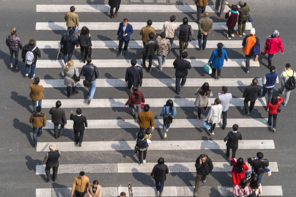 A crowd of people crossing a street.