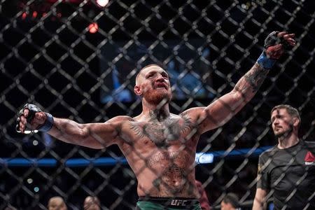 Aug 20, 2016; Las Vegas, NV, USA; Conor McGregor (blue gloves) reacts to fight with Nate Diaz (red gloves) during UFC 202 at T-Mobile Arena. Mandatory Credit: Joshua Dahl-USA TODAY Sports