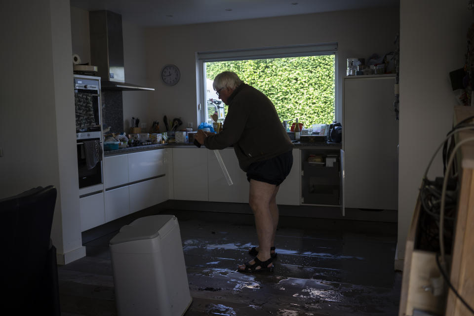 IJmert Kant assesses the damage in his home in the town of Brommelen, Netherlands, Saturday, July 17, 2021. In the southern Dutch province of Limburg, which also has been hit hard by flooding, troops piled sandbags to strengthen a 1.1-kilometer (0.7 mile) stretch of dike along the Maas River, and police helped evacuate low-lying neighborhoods. (AP Photo/Bram Janssen)