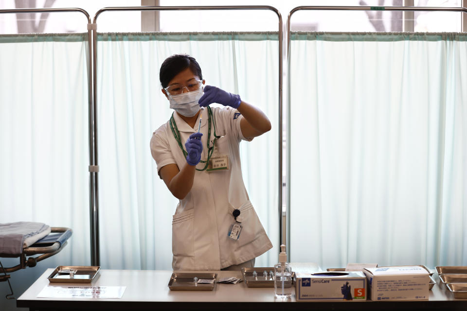 FILE - In this Feb. 17, 2021, file photo, a medical worker fills a syringe with a dose of the Pfizer COVID-19 vaccine at Tokyo Medical Center in Tokyo. Some wealthy nations that were most praised last year for controlling the coronavirus are now lagging far behind in getting their people vaccinated — and some, especially in Asia, are seeing COVID-19 cases grow. (Behrouz Mehri/Pool Photo via AP, File)