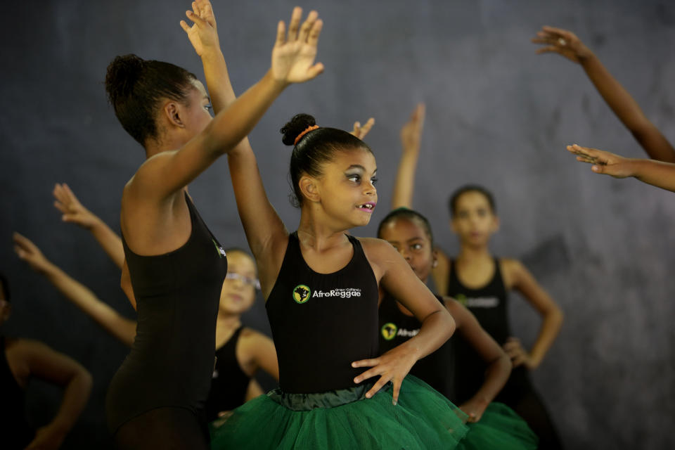 Young dancers from the Afro Reggae center perform before members of London's Royal Opera House in the Vigario Geral slum of Rio de Janeiro, Brazil, Saturday, March 2, 2013. This past week Royal Ballet dancers shared their knowledge and advice with promising artists during an education symposium between the company and the cultural arts center Afro Reggae. (AP Photo/Silvia Izquierdo)